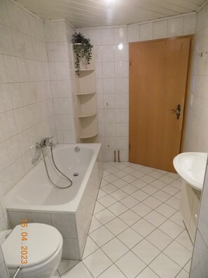 A bathroom with a bathtub, toilet, and sink. - Ferienwohnung Bohnert - Arias (Bad Peterstal-Griesbach)
