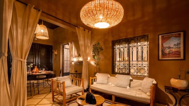 A cozy room with a sofa, chairs, a dining table, and a hanging light fixture. - Villa Cosy Piscine 5 Km du Centre Ville 4 Suites (Marrakech)
