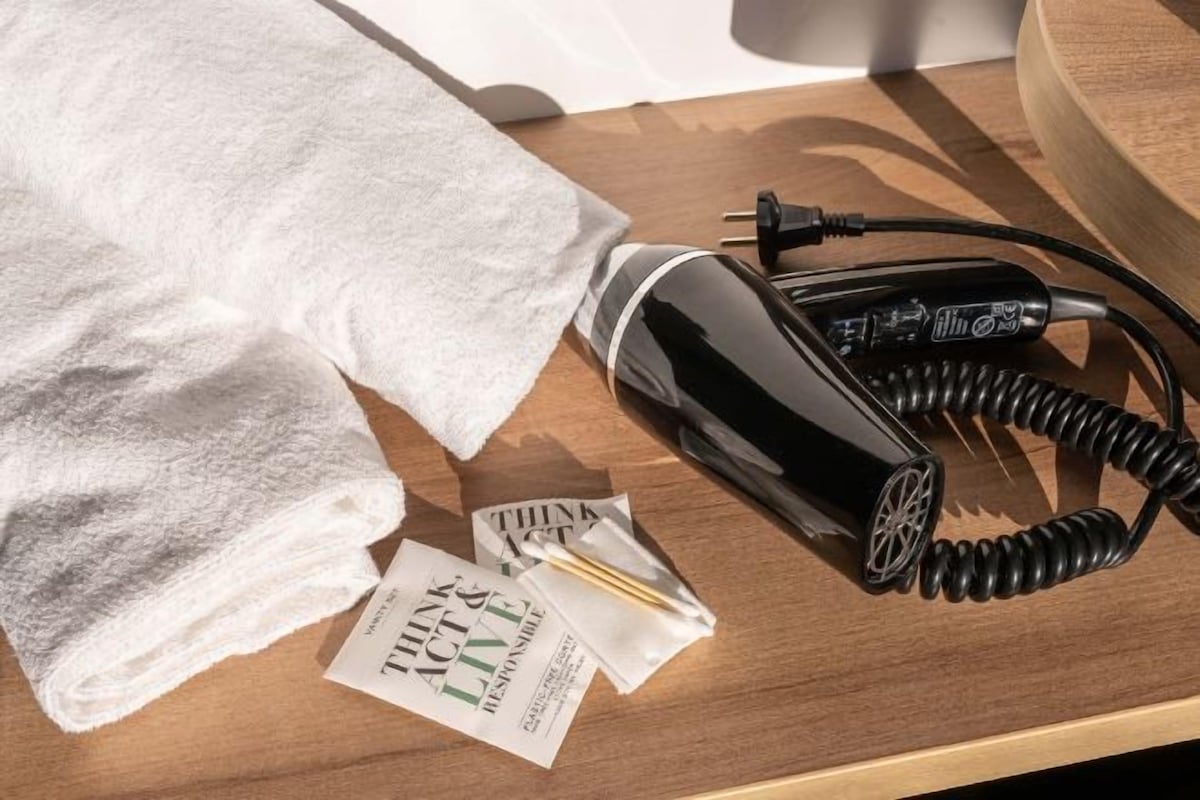 Un secador de pelo, una toalla y una tarjeta sobre una superficie de madera.