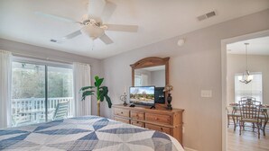 Une chambre dotée d’un grand lit, d’une commode, d’une télévision et d’un balcon aménagé avec du mobilier d’extérieur.