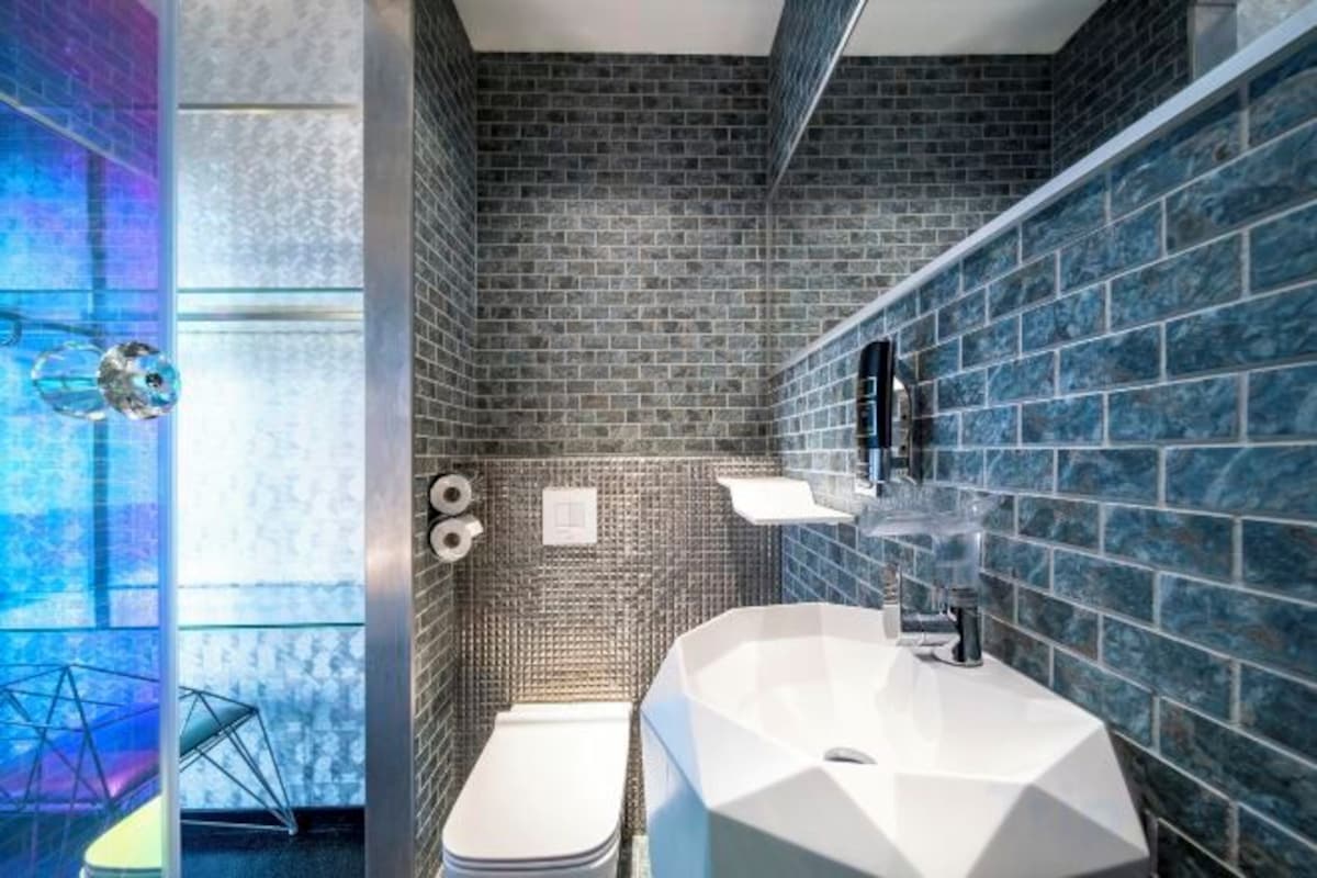 Une salle de bain avec un lavabo blanc, des toilettes et un espace douche.