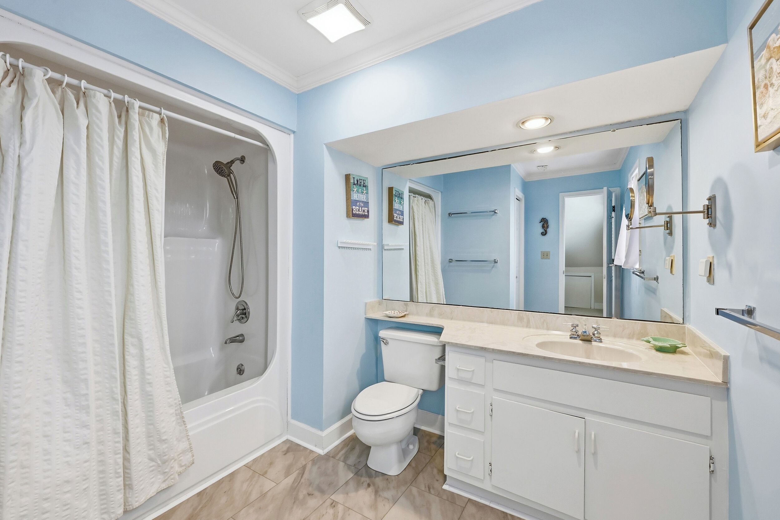 A bathroom with a bathtub, toilet, and vanity.