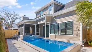 A modern two-story house with a swimming pool, large windows, and a covered patio area. - New Home in King City, Sleeps 10, Pool and Screened in Porch with TV! (St Simons Island)
