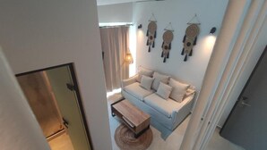 A modern living room with a sofa, a coffee table, and wall art. - Niso Skiathos (Skiathos)