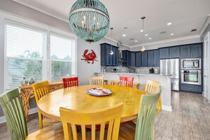 Enjoy meals in the kitchen with a round table and chairs, featuring a refrigerator, oven, and microwave.