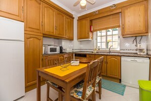 A kitchen with wooden cabinets, a microwave, a sink, and a dishwasher.