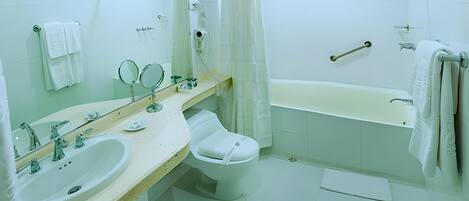 Un baño moderno con un lavabo, dos espejos, un inodoro y una bañera.