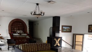 A spacious lobby with a patterned floor, a sofa, a table with chairs, and a chandelier. - Hotel Chicala S.A.S (Neiva)