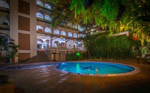 A hotel with a swimming pool, multiple floors with balconies, and lush greenery. - Hotel Chicala S.A.S (Neiva)
