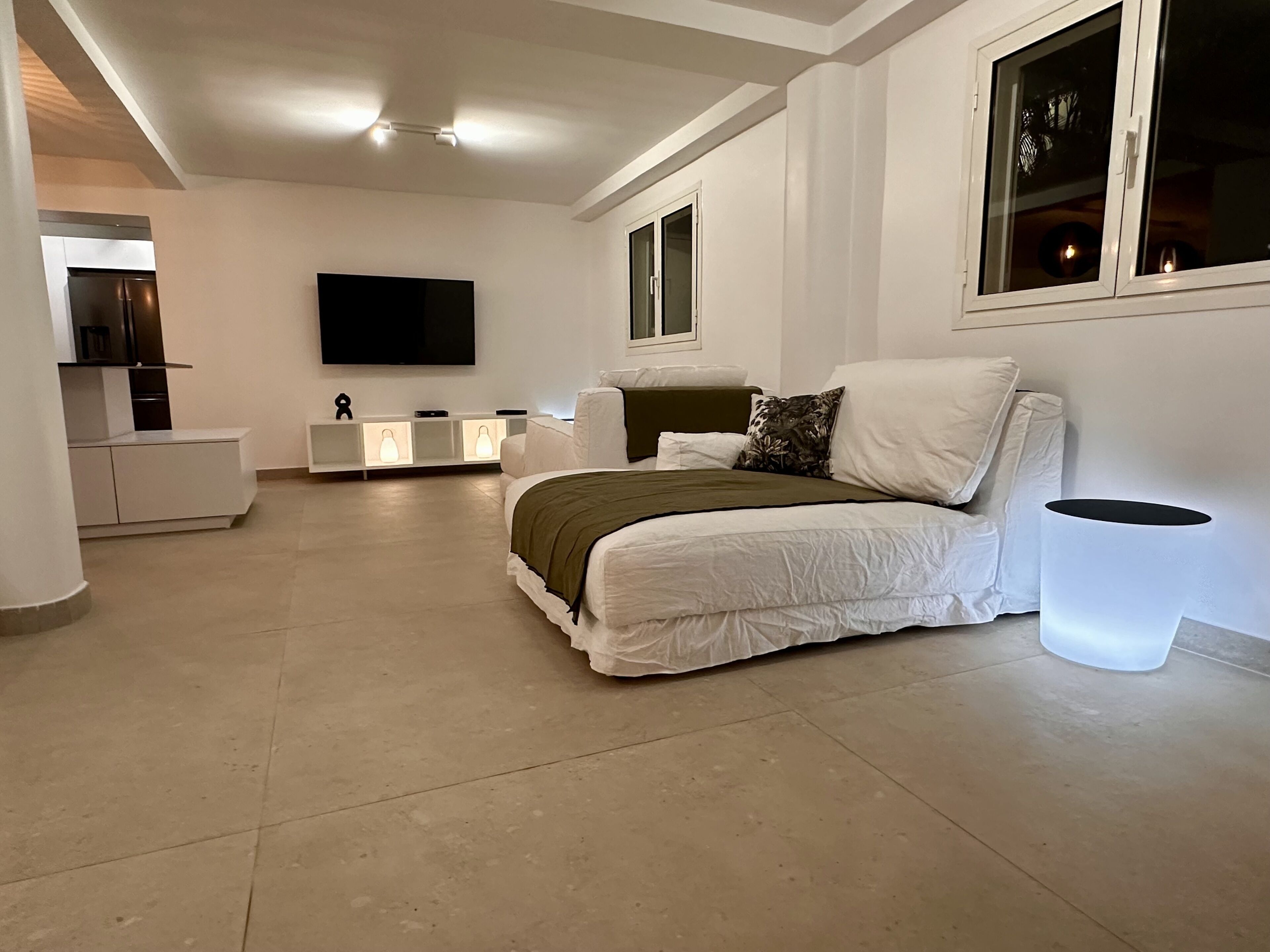 A modern bedroom with a bed, bedside table, and a TV mounted on the wall.