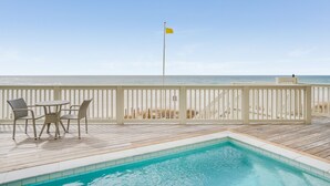 A wooden deck with a pool, white railings, and beach views. - Beach House - Whale Rested by PHG (Panama City Beach)