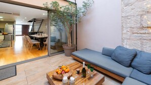 Ein modernes Wohnzimmer mit einem Holztisch, einem blauen Sofa und einer Topfpflanze.