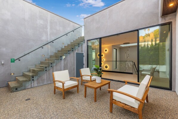 A modern outdoor seating area with a staircase leading to an upper level.