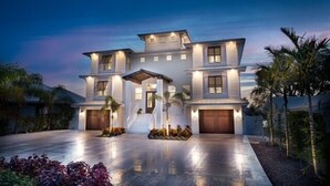 A modern two-story house with a covered driveway and a garage. - New House, Waterfront, Pool, Hot Tub, Golf Cart (Indian Rocks Beach)
