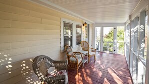 A covered porch with wicker furniture and a wooden floor. - Historic District: Downtown New Bern (New Bern)