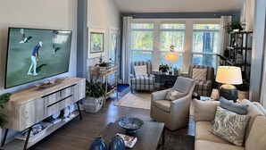 A living room with a TV, sofas, a coffee table, and a bookshelf.