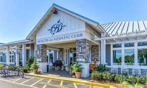 A health and aquatic club with a stone facade, outdoor seating, and a sign indicating establishment year 2017. - Bayside Resort * New Listing * 5BR home w 2  Maste (Selbyville)