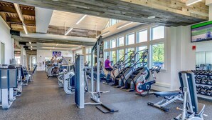 Un gimnasio con cintas de correr, máquinas de pesas y mancuernas.