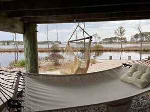 A hammock under a wooden structure with a view of a body of water and trees. - Bethany Beach Waterfront House w Stunning Views * (Bethany Beach)