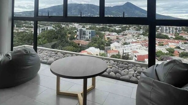 Ein stilvolles Wohnzimmer mit großem Fenster, einem runden Tisch und zwei Sitzsäcken.