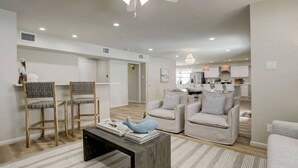 Un salon moderne comprenant un canapé, une table basse et un ventilateur de plafond.