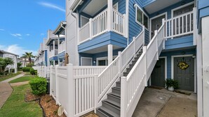Un hilero de casas urbanas con barandillas blancas y una escalera central.
