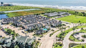 A coastal residential area with a marina, a pier, and a large parking lot. - Coastal Paradise | 2 Bedrooms | Pool | by Rose (Galveston)