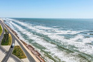 Une route côtière avec un pont enjambant l’océan, une plage et une autoroute.