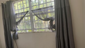 A room with a window covered by curtains, a mattress, and a wall with a visible crack. - Charming 2-bed Villa in The Garden (Holetown)