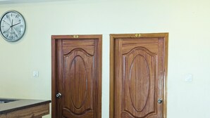 Dos puertas de madera con los números 1 y 2, un escritorio de madera y un reloj de pared.