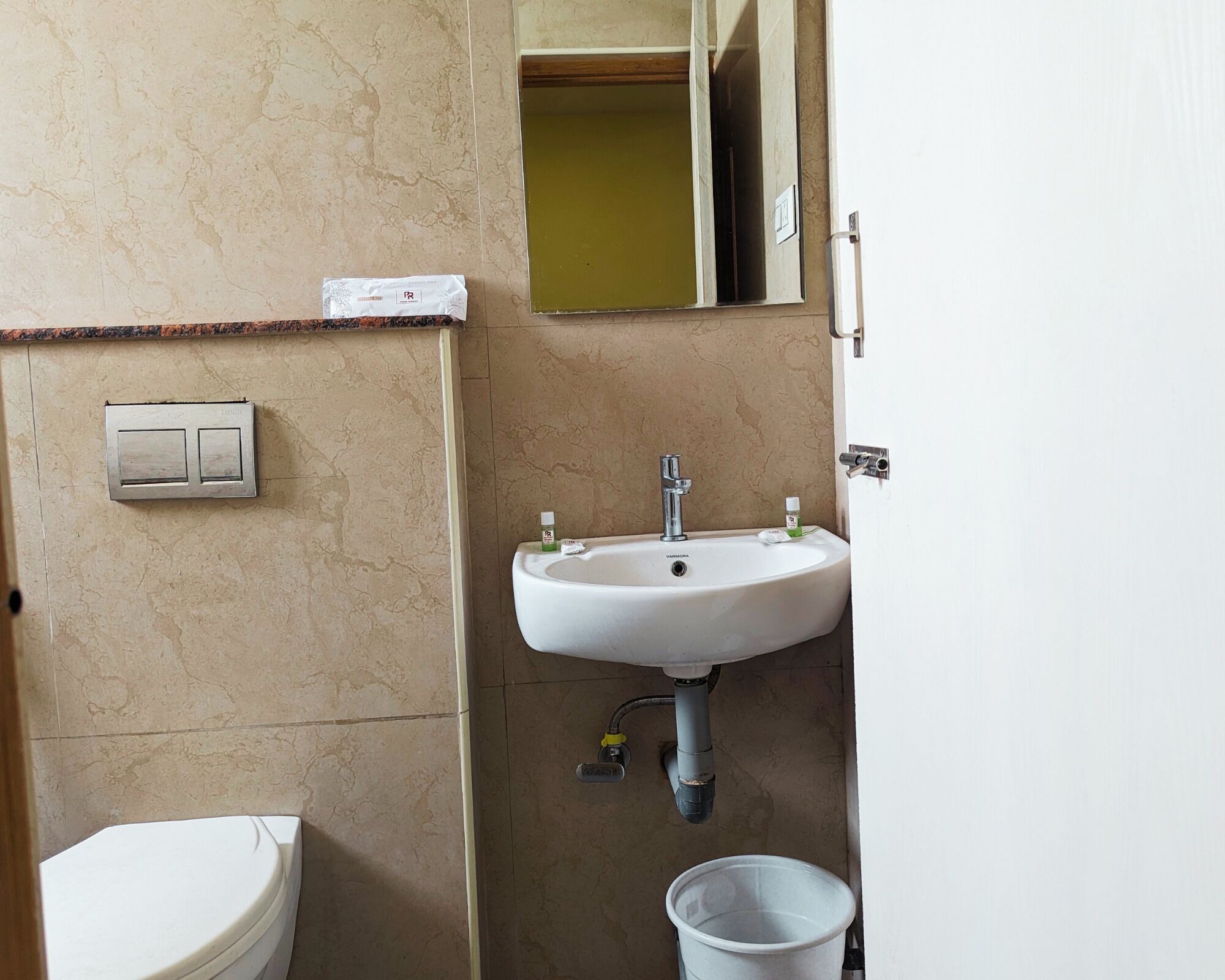 A bathroom with a white sink, a toilet, and a mirror.