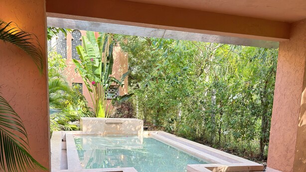 A modern outdoor seating area with a pool, surrounded by lush greenery. - Al Mahali Villas (Diani Beach)