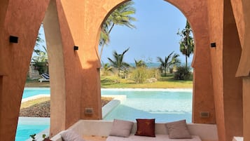 Relax by the serene pool surrounded by lush greenery and tropical plants.