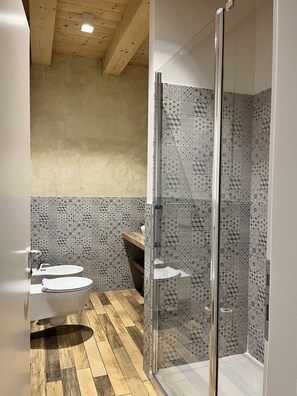Enjoy a refreshing shower in this bathroom with a glass-enclosed shower area and sink with a wooden countertop.