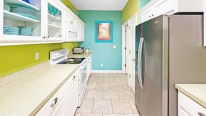 A kitchen with white cabinets, a stainless steel refrigerator, a microwave, and a toaster.