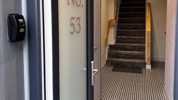 A hallway with a door labeled "No. 53" leading to a staircase.