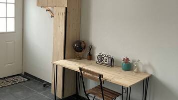 Ein Eckzimmer mit Holztisch, Globus, einer Uhr und einem kleinen Regal mit Dekoration.