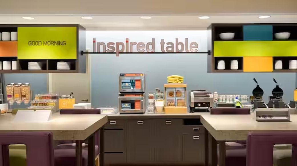 A cafe with a 'Good Morning' sign, a display of breakfast items, and a 'Inspired Table' sign.