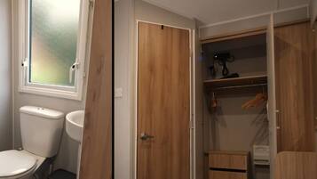 Doble habitación con baño privado, armario de madera y un pequeño espacio de almacenamiento.