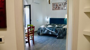 Une chambre à coucher avec un lit, une chaise, un bureau et un tableau accroché au mur.