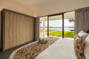 A bedroom with a large bed, a view of the sea, and a balcony with a lawn. - Amã Stays & Trails Anchorage Vypin, Cochin (Kochi)