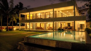 A modern two-story building with an outdoor swimming pool, large windows, and a balcony. - Amã Stays & Trails Anchorage Vypin, Cochin (Kochi)