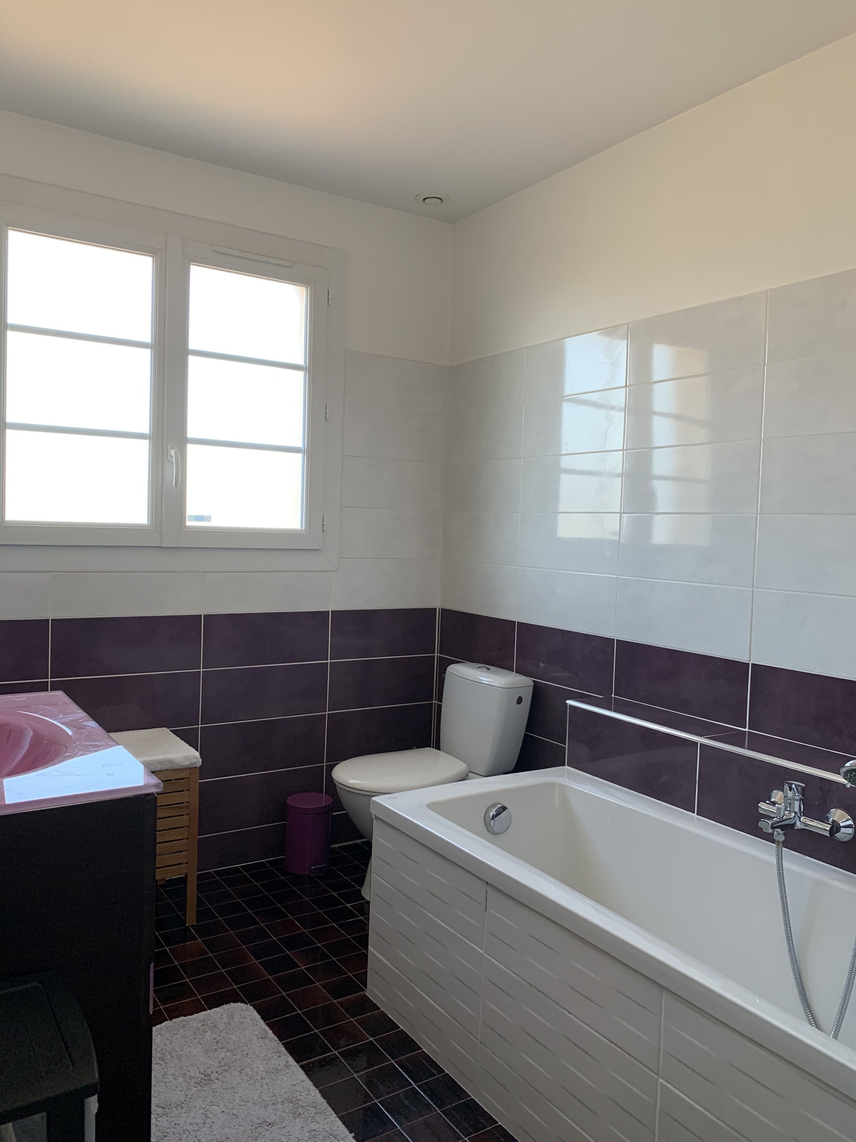 Een badkamer met een bad, toilet en wastafel.