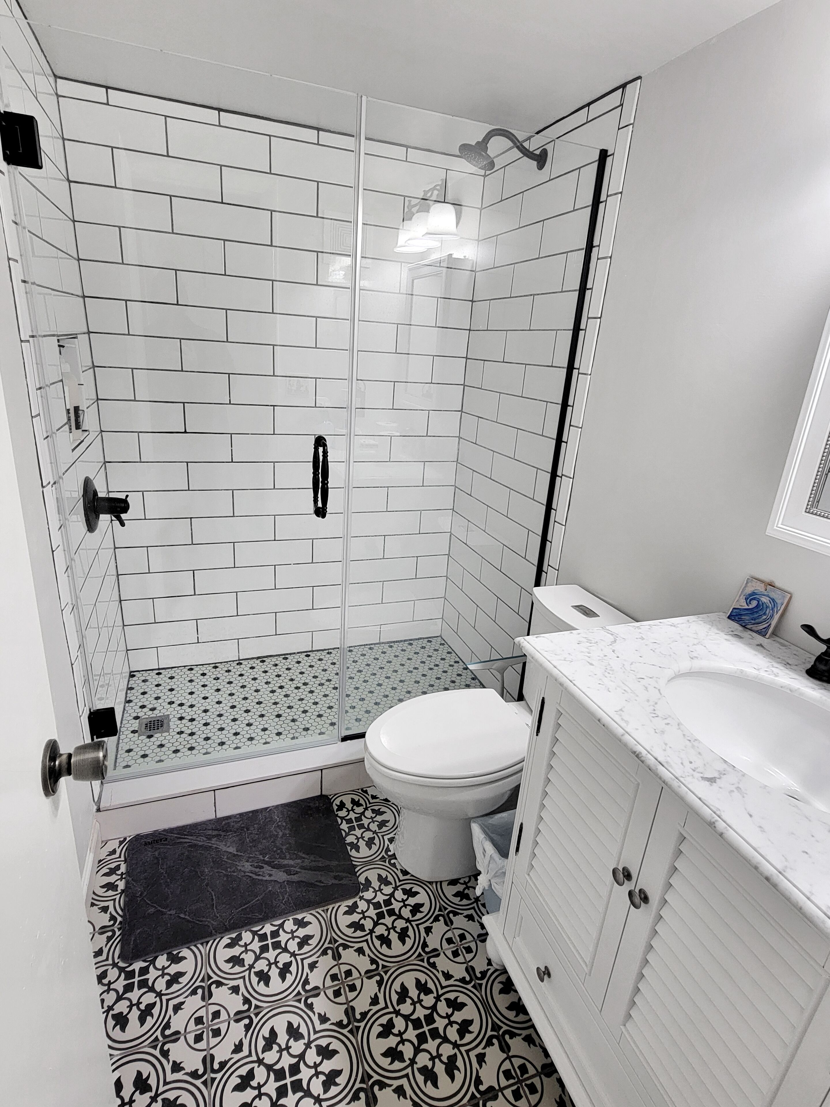 A bathroom with a shower, toilet, and vanity.