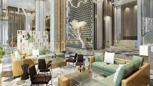 A modern lobby with seating areas, a decorative wall, and a staircase.