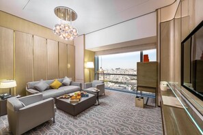 Une chambre d’hôtel moderne avec un canapé, une table basse et une vue sur la ville.