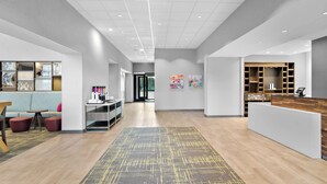 A modern hotel lobby with a reception desk, seating area, and artwork on the walls. - Hampton Inn & Suites Chicago Medical District UIC (Chicago)