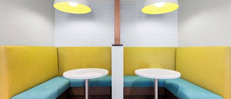 Een zithoek met een ronde tafel en twee hanglampen.