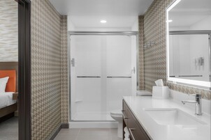 Un baño moderno con ducha, inodoro y lavabo.
