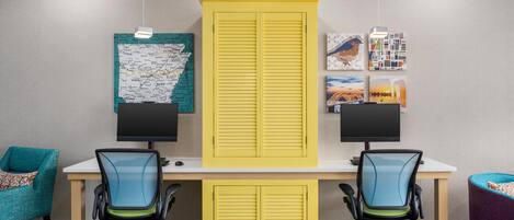 A workspace with two desks, chairs, and a large yellow cabinet.